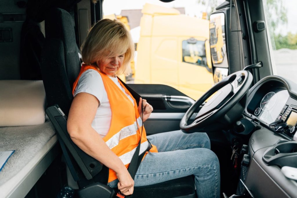 Conducente del camion che allaccia la cintura di sicurezza