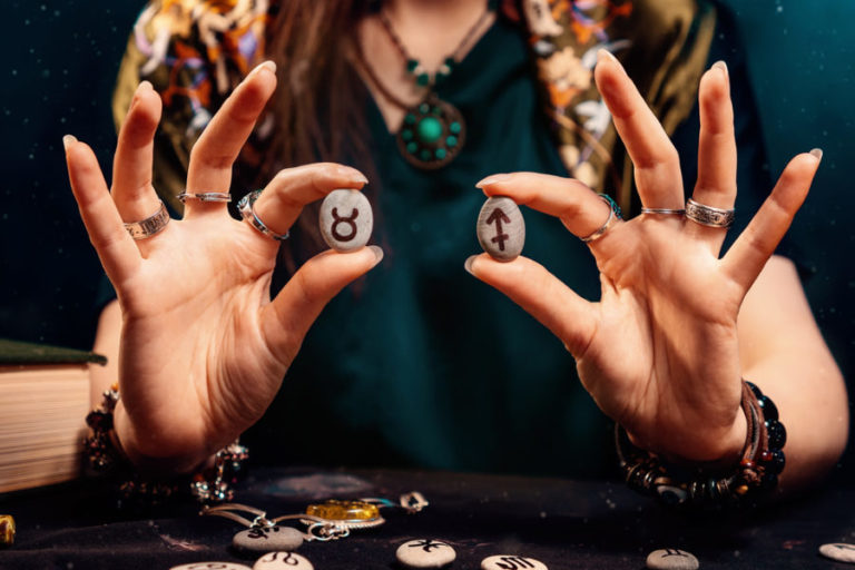 Astrology and horoscope. Female's holds stones with the zodiac sign of Taurus and Sagittarius. The concept of compatibility of partners according to the signs of the zodiac