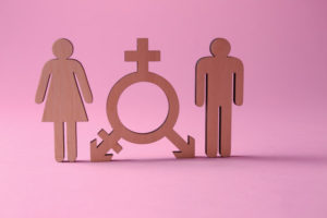 Female and male figures with symbol of transgender on color background