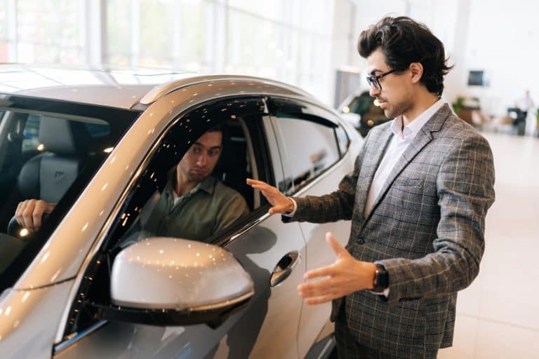 Venditore concessionaria mostra al cliente auto in vendita.jpg