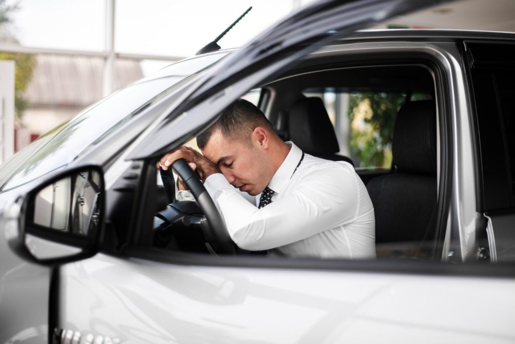 vista frontale maschio con testa appoggiata sul volante.jpg