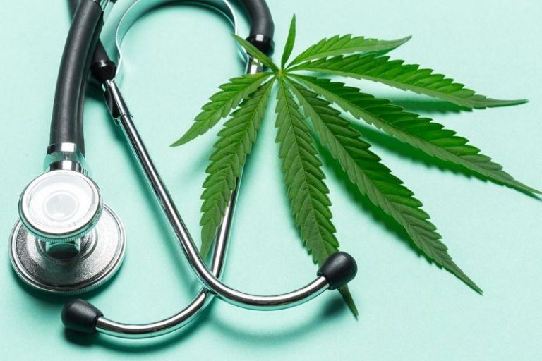 a cannabis leaf next to a stethoscope on a turquoise background m.jpg