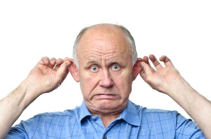 photograph of an older man in a blue shirt pulling out his ears and making a worried face m.jpg