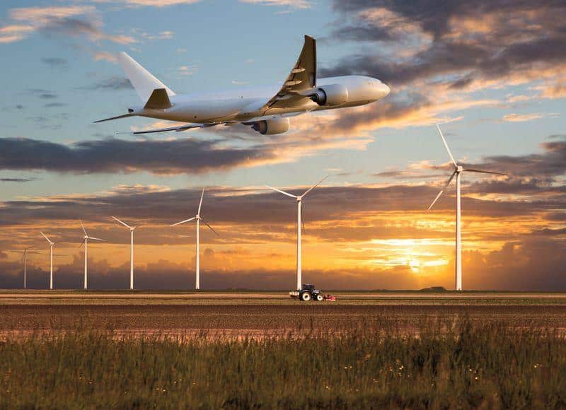 plane takes off above a farm field and wind electric generators m.jpg