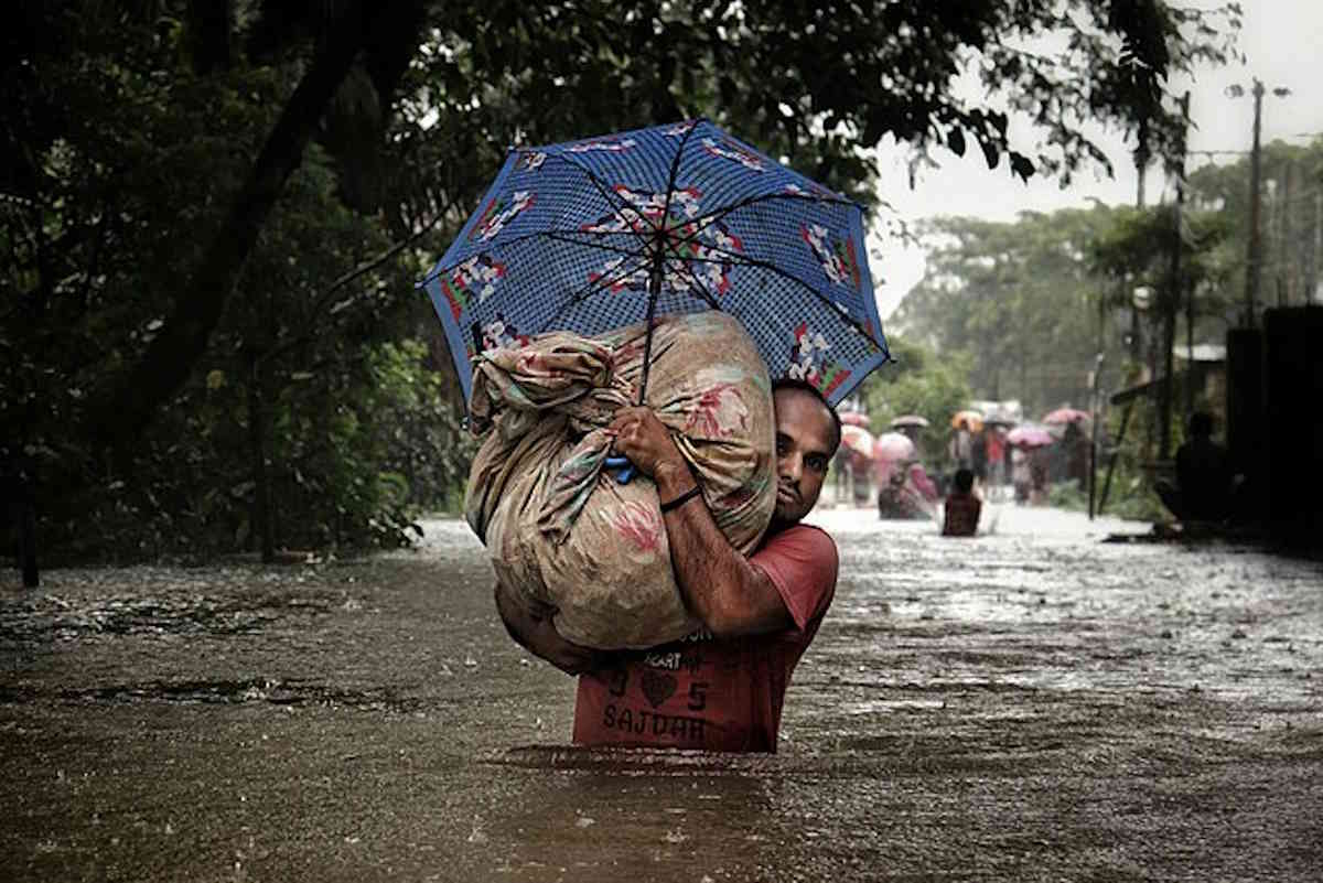 Urban man leaving his house due to flash flood Sylhet Bangladesh.jpg
