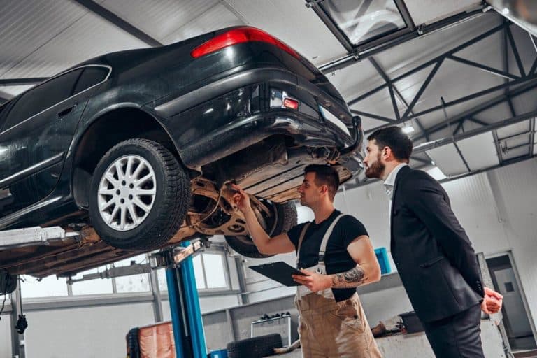 Meccanico mostra i guasti auto e il preventivo dei costi di riparazione al cliente in officina e1718263862581.jpg
