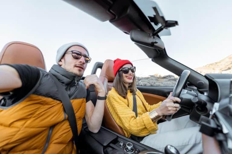 coppia di giovani che viaggia in auto cabrio e1730974890309.jpg