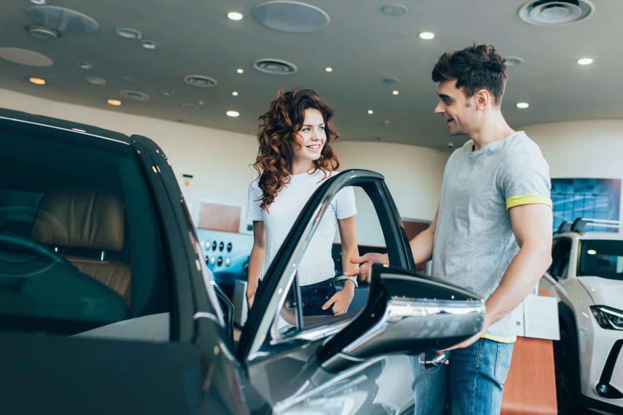 Venditore di auto usate parla con il cliente intento a provare il veicolo e1712649274212.jpg
