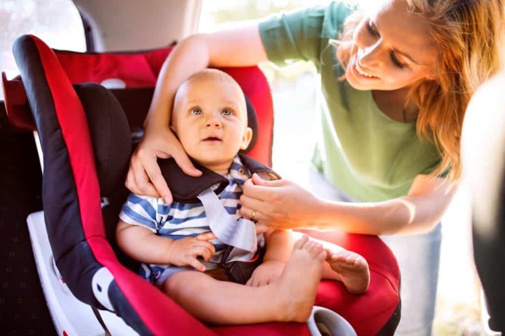 Mamma allaccia bambino nel seggiolino auto e1718643194542.jpg